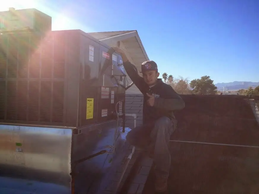 HVAC technician performing AC Tune-Up on a rooftop unit in North Richland Hills